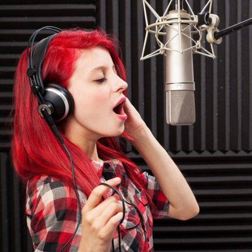 portrait of young woman recording a song in a professional studio